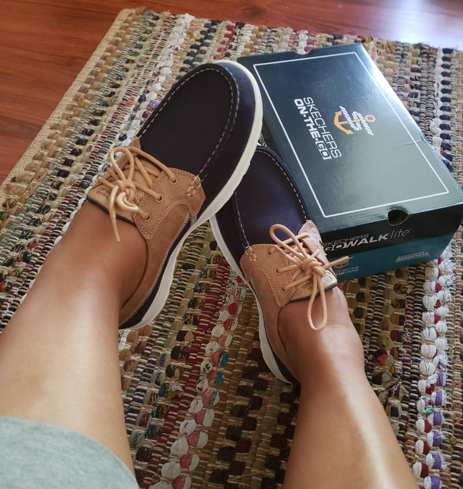 A photo from a reviewer showcasing the navy blue and tan Skechers boat shoes.