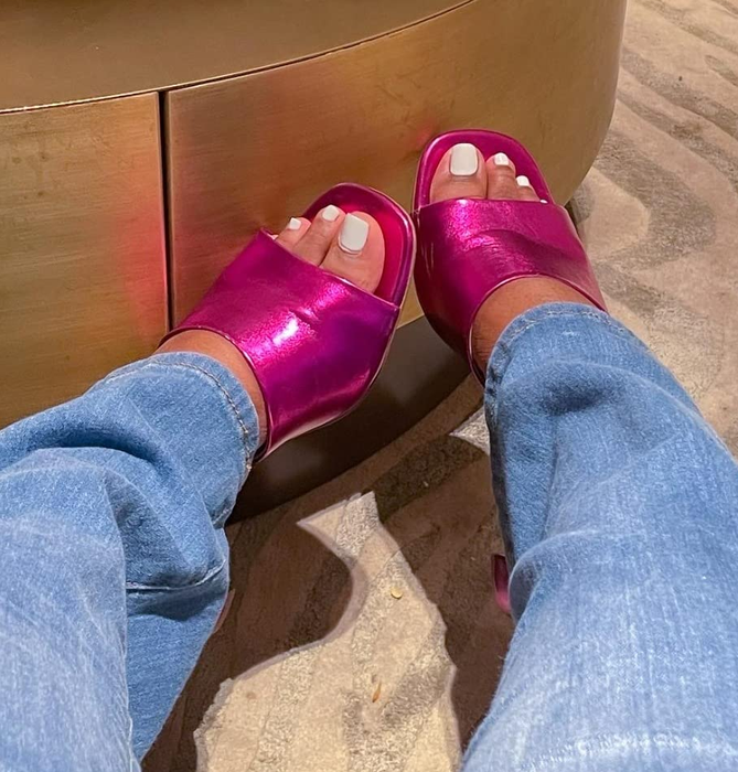 A reviewer wearing the pink metallic mules with jeans