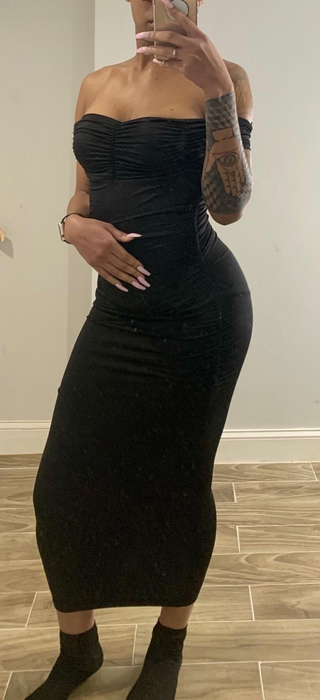 A reviewer in a black dress taking a mirror selfie