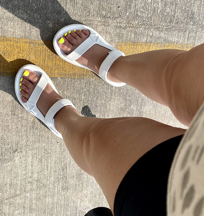 a reviewer wearing the white sandals