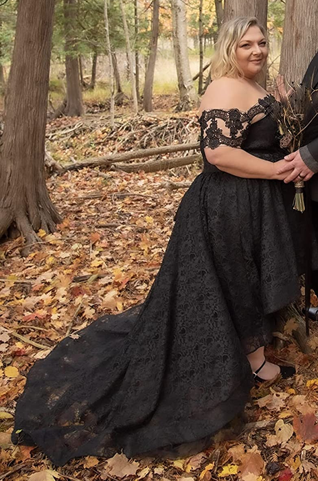 A reviewer wearing the black dress in an outdoor setting