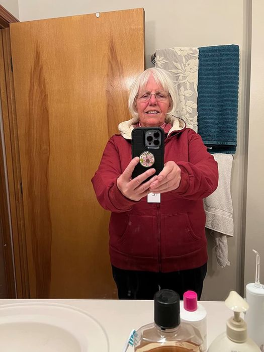 A reviewer styled in a red hoodie paired with black pants