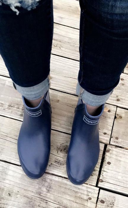overhead view of reviewer wearing black boots paired with rolled-up jeans