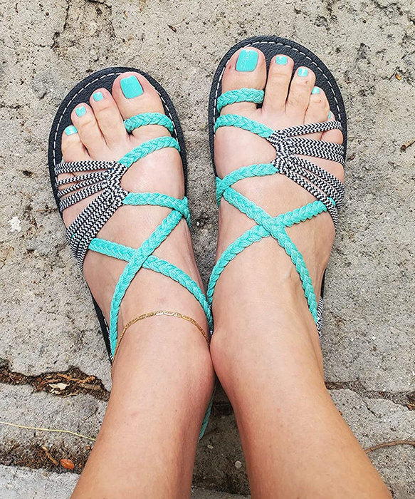 A reviewer wearing the teal sandals