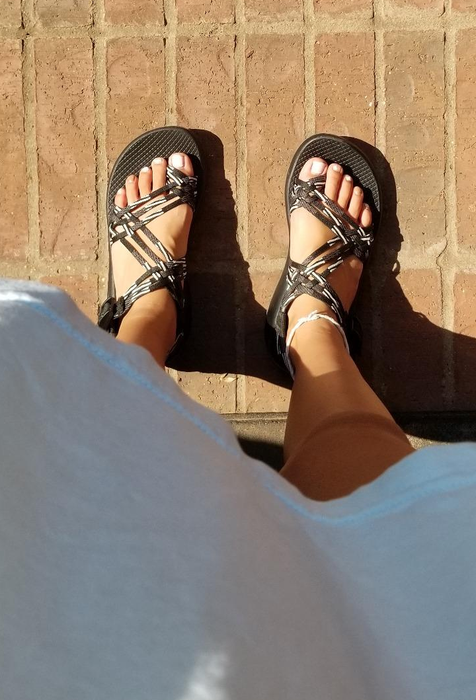 A reviewer wearing black and white Chacos