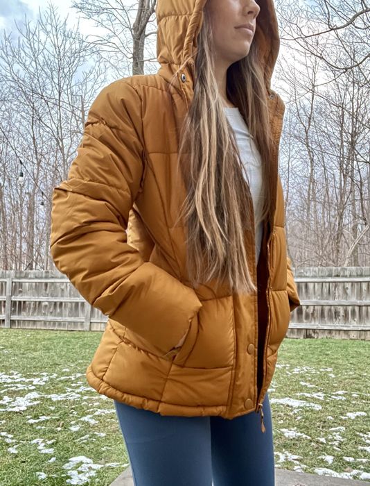 A reviewer styled in a yellow coat, blue pants, and a white top