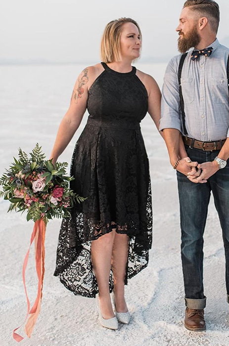 A reviewer in the black hi-low dress at a beach