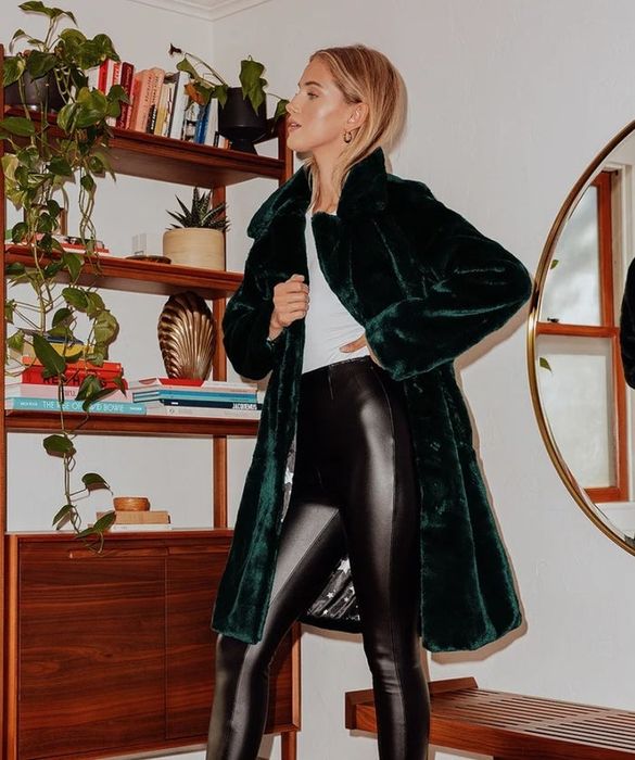 Model showing off the dark green long coat