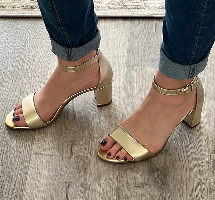 A reviewer wearing the gold heels
