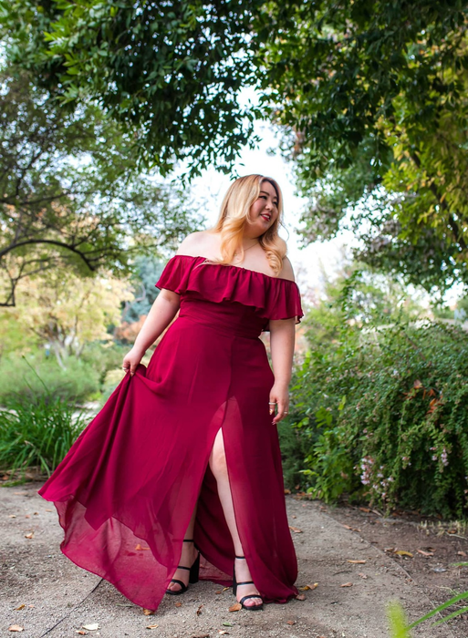 A person modeling the dress in a vibrant red hue