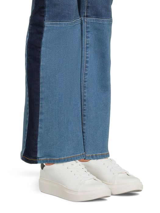 a model wearing the white sneakers with jeans