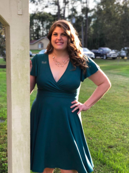 A reviewer wearing the dress in a green hue