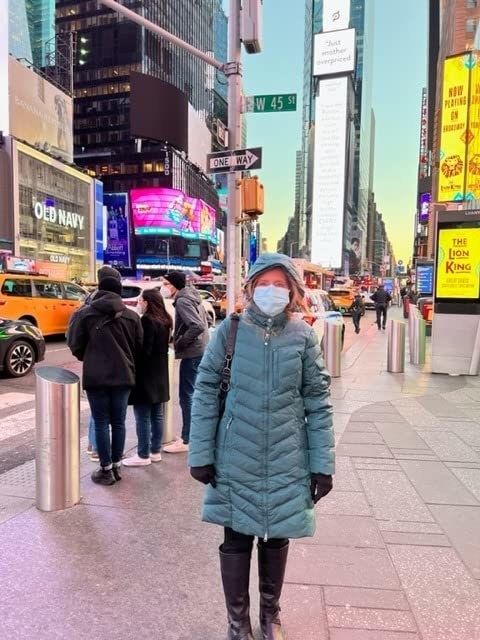 A reviewer wearing a blue coat in New York City