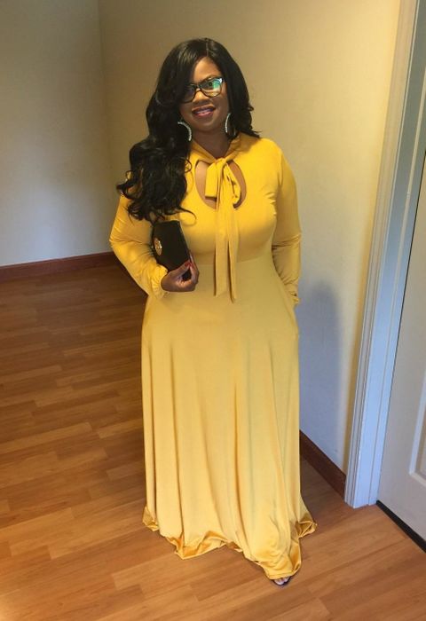A reviewer modeling the long-sleeved dress in a vibrant yellow