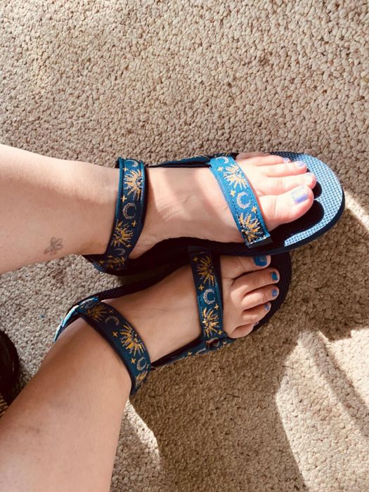 different reviewer wearing the same sandals in a blue sun and moon pattern