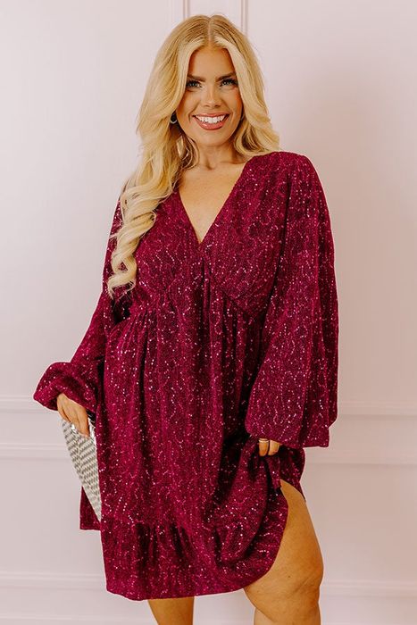 A model in a sparkly, deep V-neck, long-sleeve dress for a shopping feature