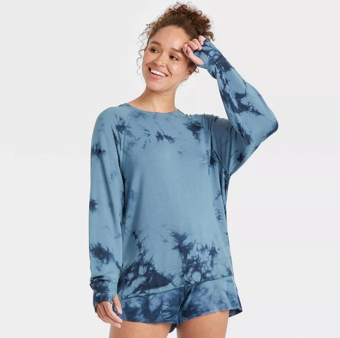 A model wearing the same lightweight workout sweatshirt in a trendy antique blue tie-dye pattern