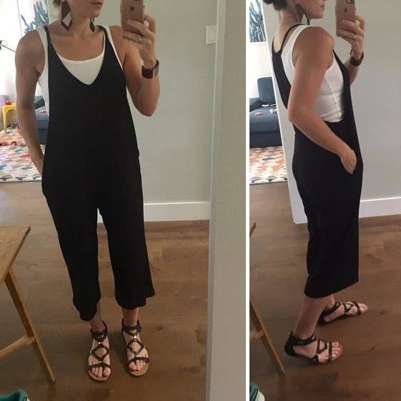 a reviewer modeling the black jumpsuit with a white tank top underneath