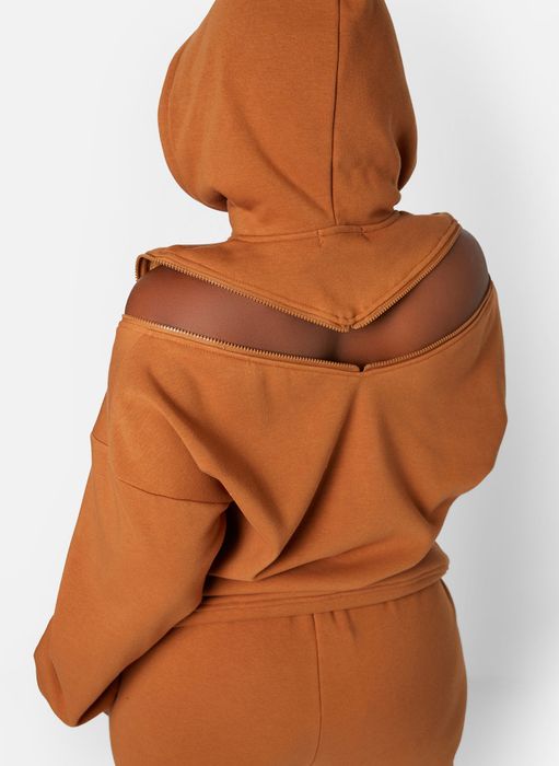 a model showcasing the back of the sweatshirt with its v-shaped zippered opening