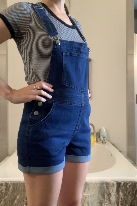 A reviewer wearing overall shorts