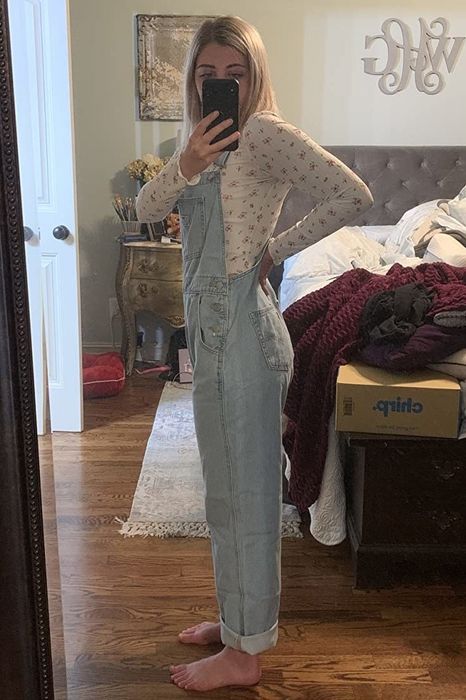 A reviewer modeling denim overalls