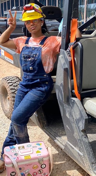 A reviewer modeling the denim Carhartt overalls