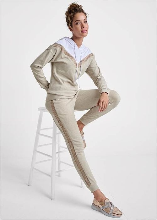 a model wearing the beige set with a gold sequin stripe