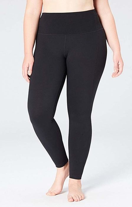 A plus-size model showcasing sleek black high-rise leggings