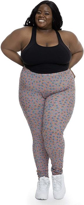 A model wearing a black tank top and multicolored floral leggings