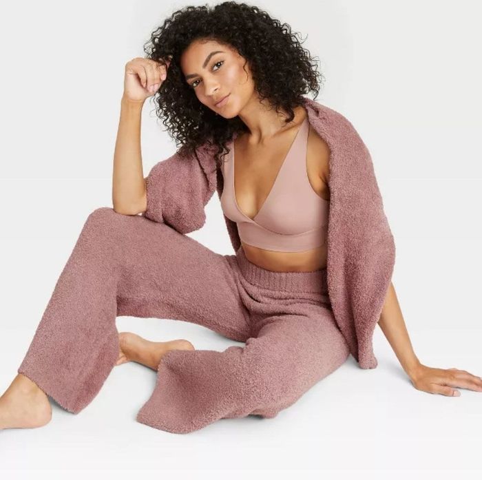 A model wearing the pink pants paired with a matching cardigan