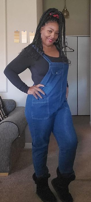 A reviewer modeling denim overalls
