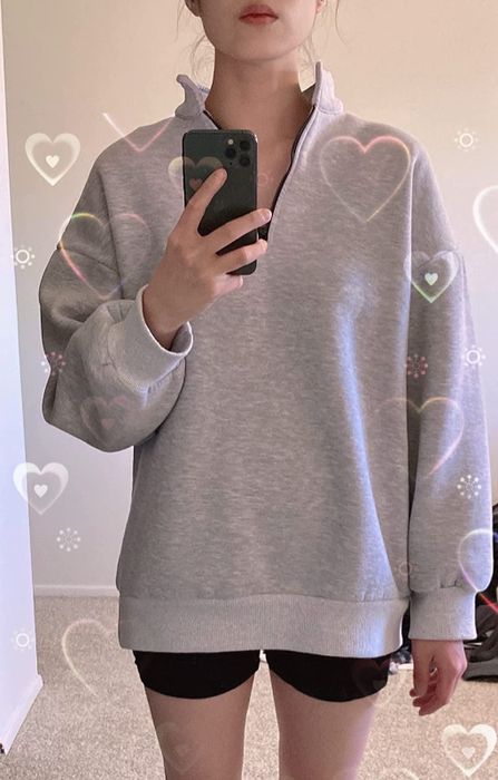 a reviewer modeling the grey version of the sweatshirt