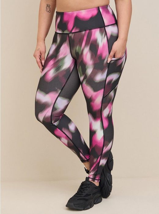 A model showcasing the brush paint pattern leggings in pink, white, and black