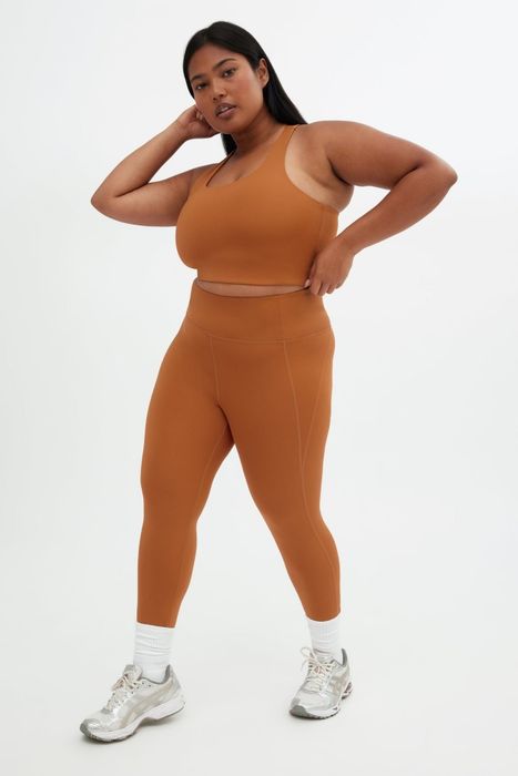 A confident individual poses in a matching activewear set and sneakers