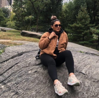 a reviewer showcasing the tan jacket