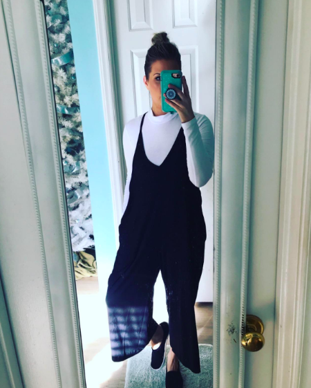 a reviewer wearing the black jumper with a long-sleeved white shirt underneath