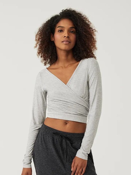 a model wearing the criss-cross v-neck sweater in light grey