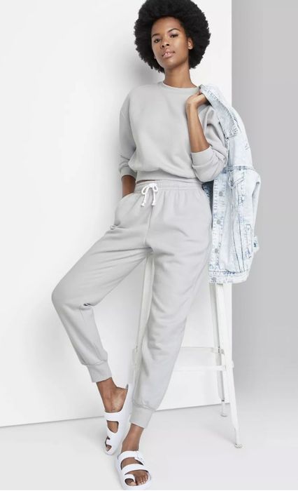 A model wearing grey high-rise sweatpants paired with a long-sleeve grey shirt