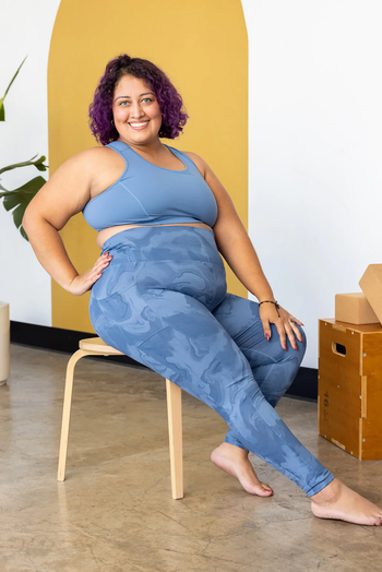 A model wearing high-waisted blue marble print leggings with pockets