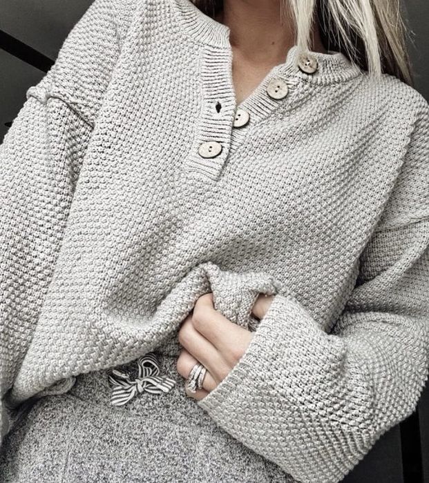 A grey oversized sweater with a relaxed fit