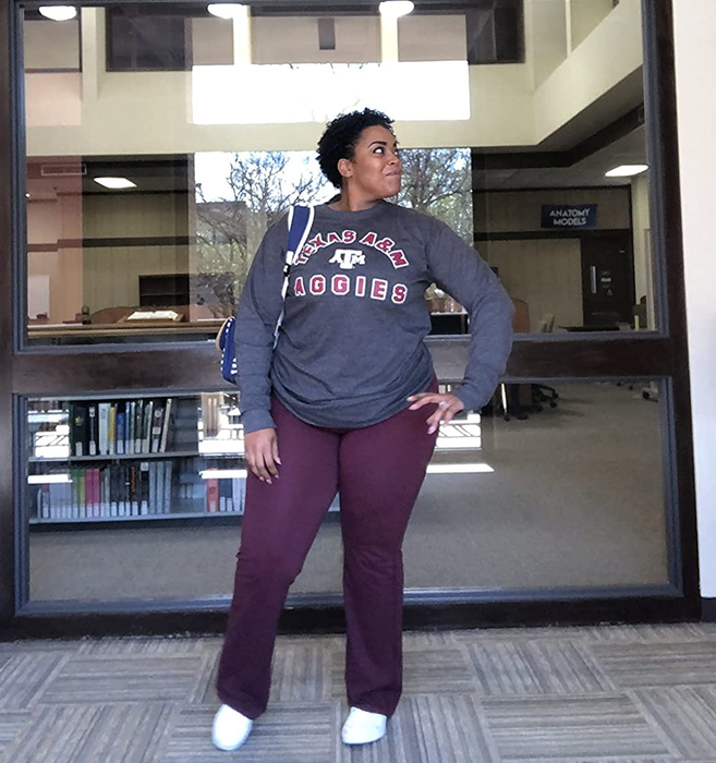 A reviewer's photo showcasing berry-colored flared leggings paired with a gray long-sleeve tee and white sneakers
