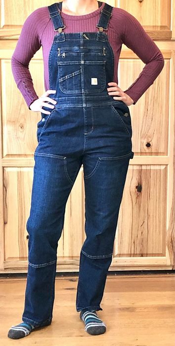 A reviewer wearing the denim Carhartt overalls