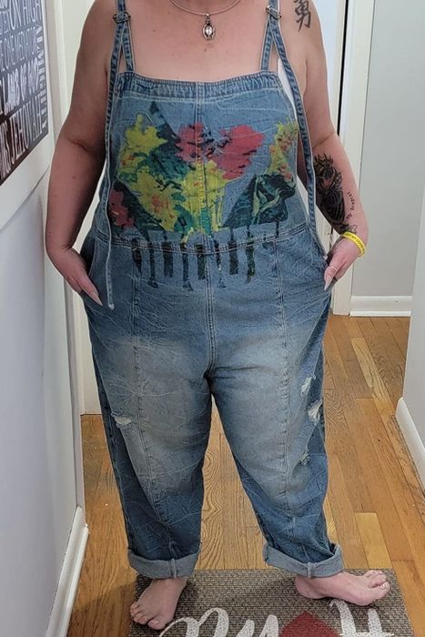 A reviewer modeling painted overalls
