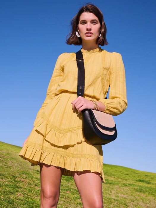 Model wearing a long-sleeve woven pullover top