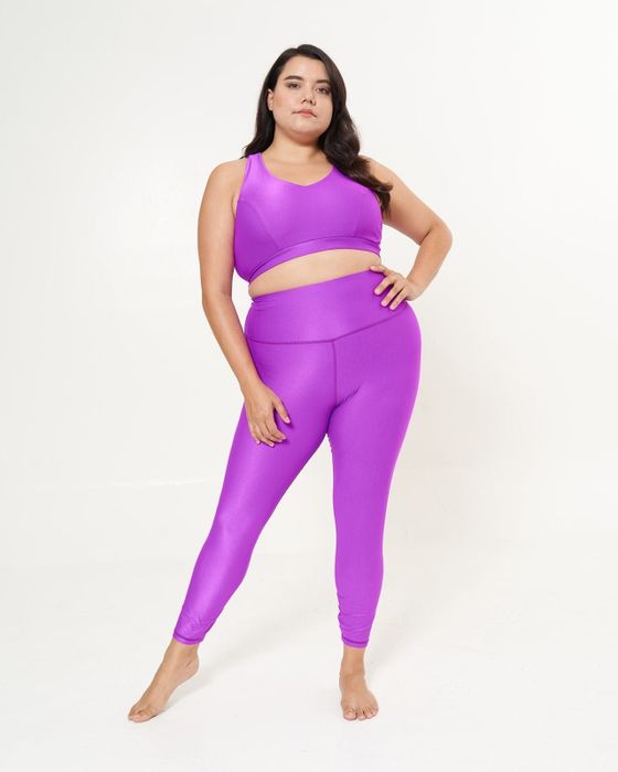 A model showcases shiny fuchsia ribbed leggings paired with a matching sports bra