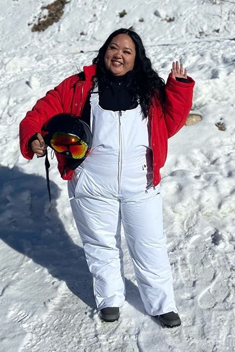 A reviewer showcasing white overalls