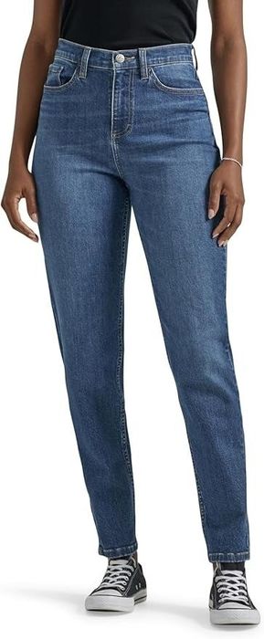 A model rocks a casual look with blue denim jeans, a black top, and classic black Converse sneakers.