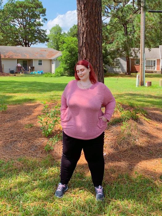 Another reviewer wearing the pink tee with hands tucked into the pockets