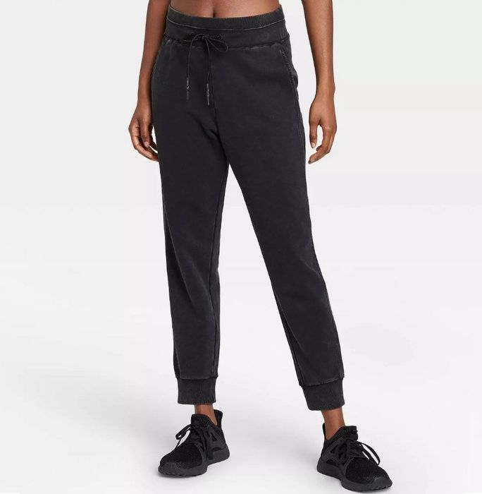 A model showcasing a pair of mid-rise French terry joggers in classic black