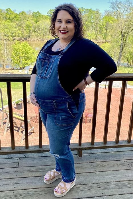 A reviewer showcasing the maternity overalls